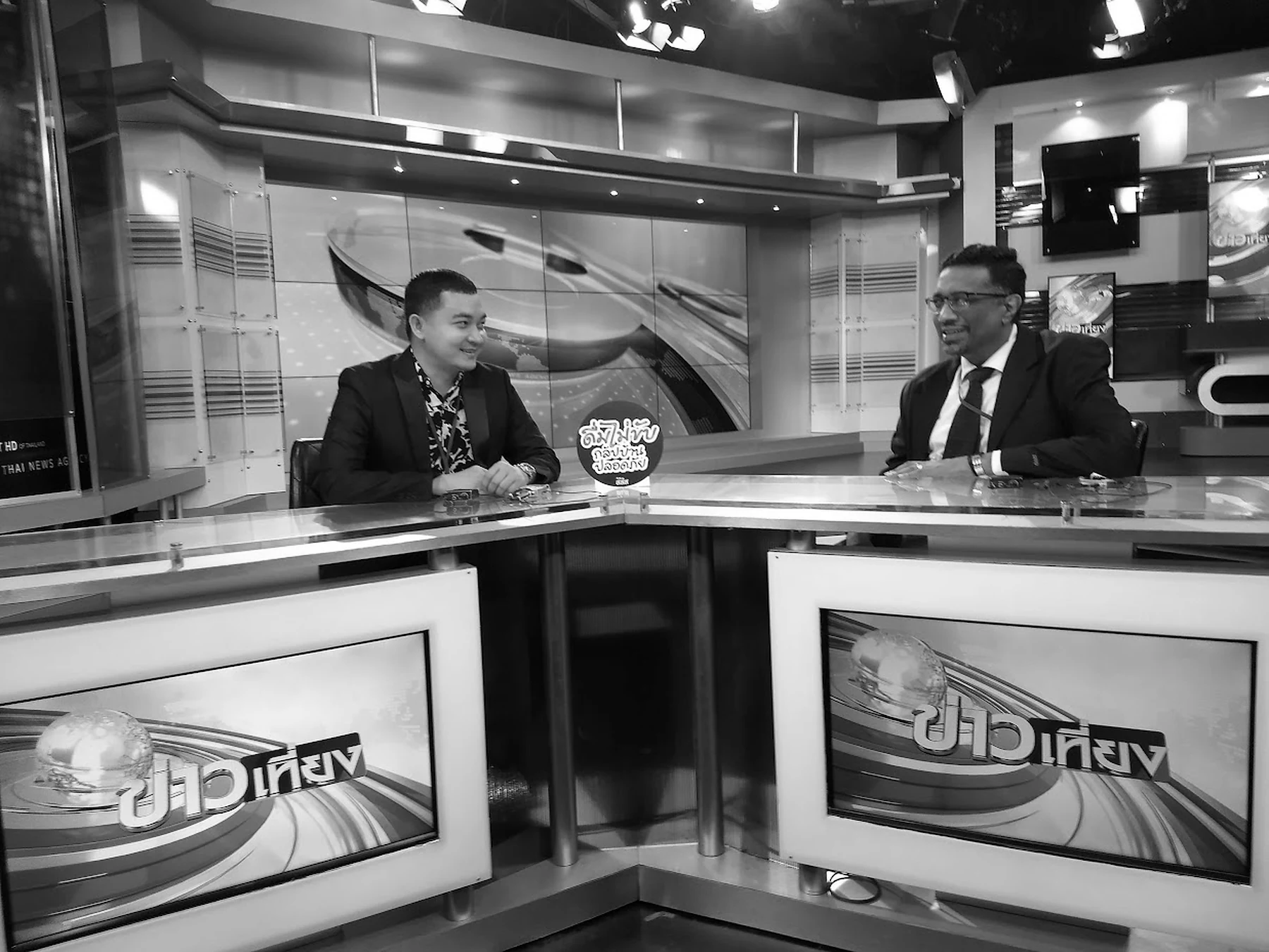 Ravi discussing a story with a television presenter inside a news studio